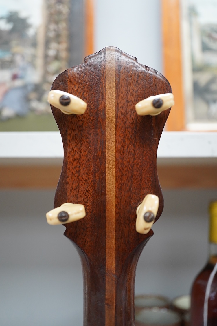 A cased Vega 4-string tenor banjo stamped M. Roccia, steel body with veneered back, the case embossed with; Ronald Quilter, 10, Cadogan Lane, London S.W.1., overall length 82cm